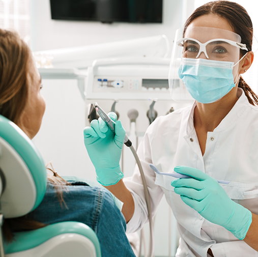 Dentist showing patient a piece of equipment