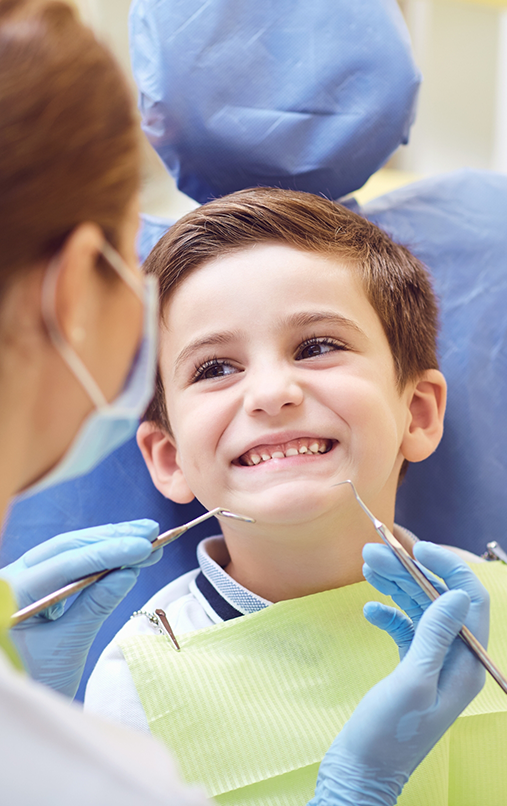 Child in dental chair smiling up at childrens dentist in Bellaire