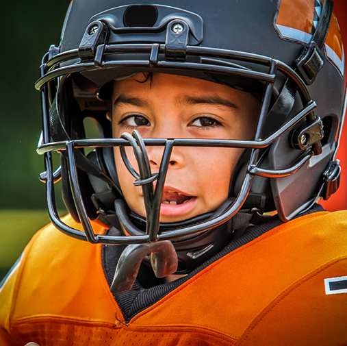 Small child wearing a football helmet