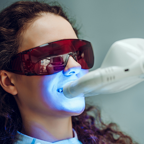 Woman with protective glasses receiving teeth whitening