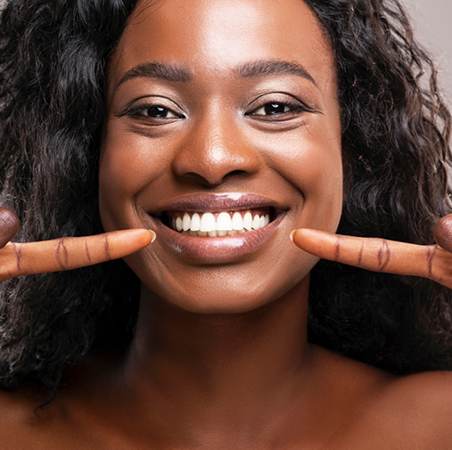 Woman smiling and pointing to her teeth