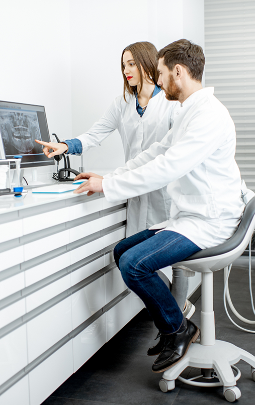 Two dentists in Bellaire looking at X ray of teeth on monitor