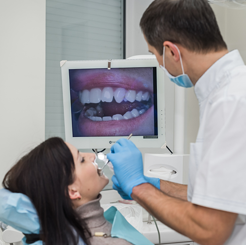 Male dentist scanning womans teeth with intraoral camera