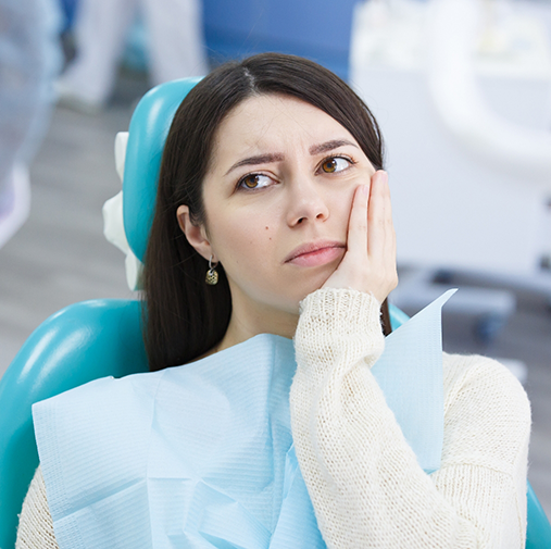 Woman in dental chair with tooth pain visiting emergency dentist in Bellaire