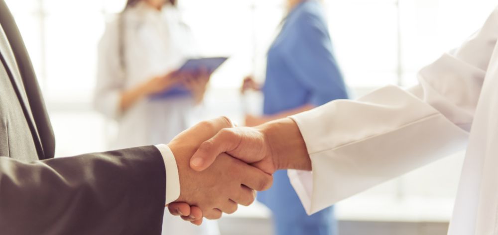 Close up of dentist and patient shaking hands