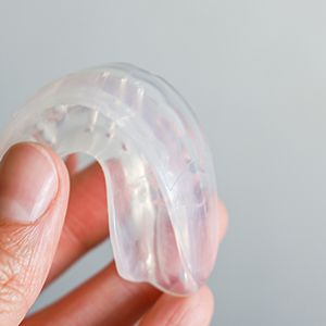 Closeup of patient holding clear mouthguard