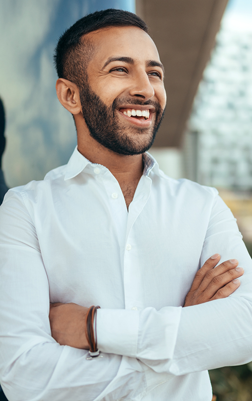 Man with beard smiling with arms folded